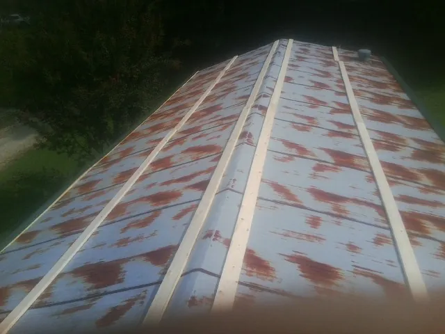 Rusted metal roof panels with new wood purlins before replacement — Storm Damage Roof Repair in Jenners by Roofing Brothers