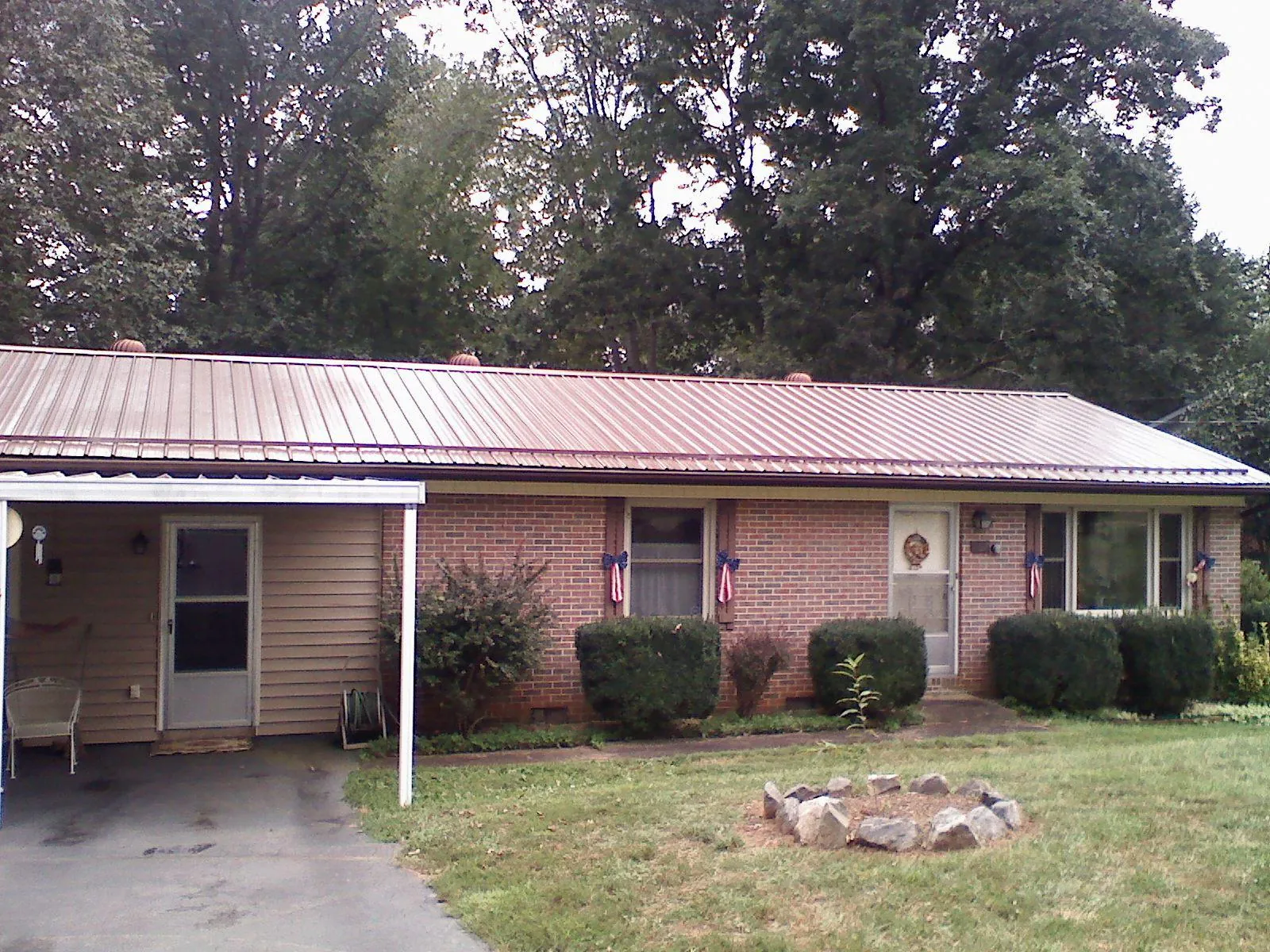 Bronze metal roof and carport on a brick ranch home — Roof Repair work by our crew in Jenners